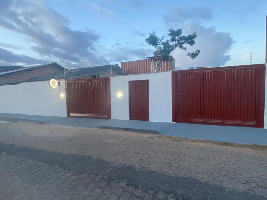 un bâtiment avec des portes rouges et blanches dans une rue dans l'établissement Container LB CAXU, à Boa Vista