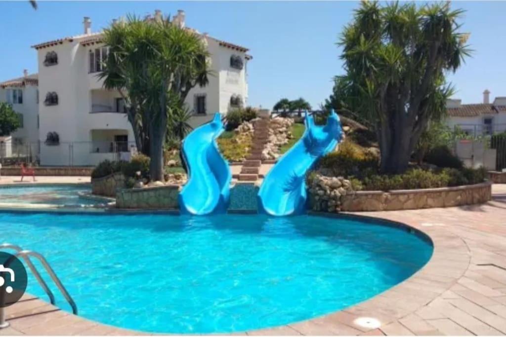 una piscina con due delfini blu in acqua di En Denia, urbanización el palmar con piscina, toboganes y chiringuito a Denia