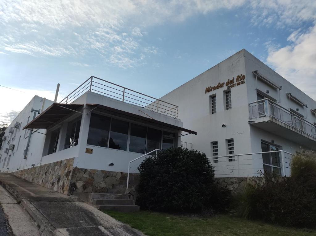a white building with a balcony on the side of it at Mirador del Río Apart Hotel in Victoria