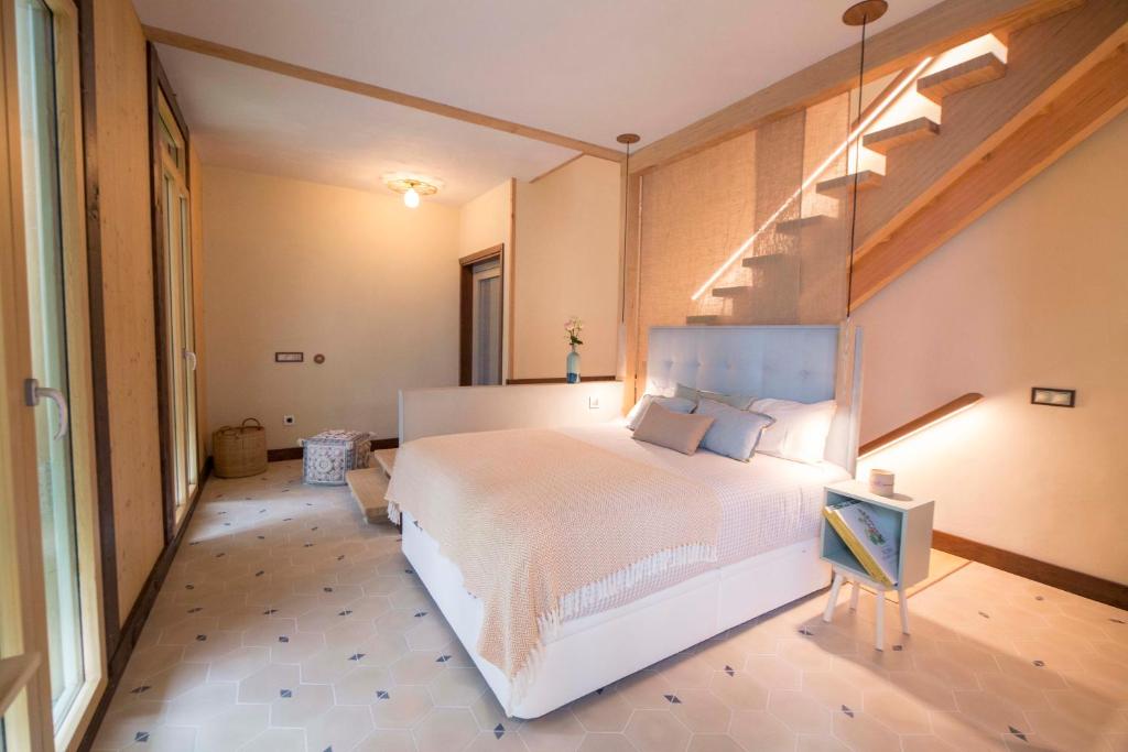 a bedroom with a large white bed and a staircase at The Wooden House VV in Las Palmas de Gran Canaria