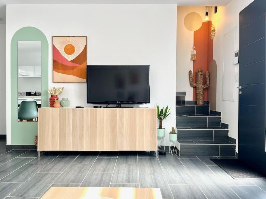 un salon avec une télévision sur un meuble en bois dans l'établissement Maison Cosy à 500 m de la plage de la Couronne, à La Couronne