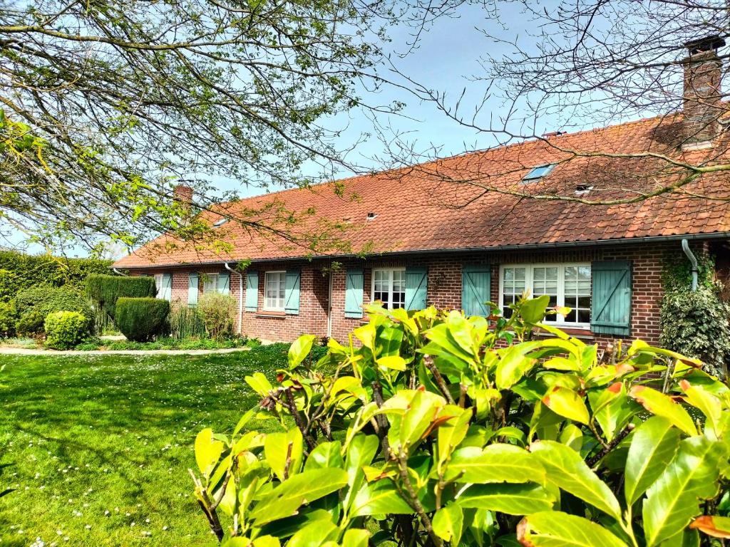 una casa con un arbusto verde delante de ella en La Mouillère en Verton