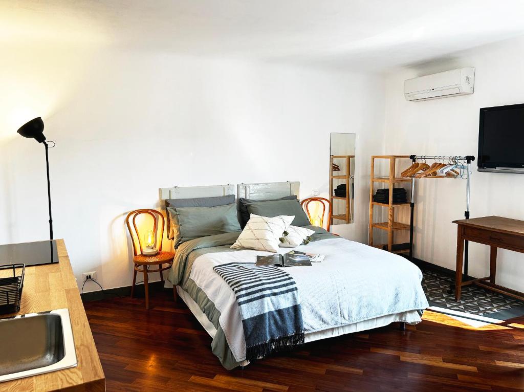 a bedroom with a bed and a desk and a television at Il Dolce Far Niente, La Serra di Lerici in Lerici