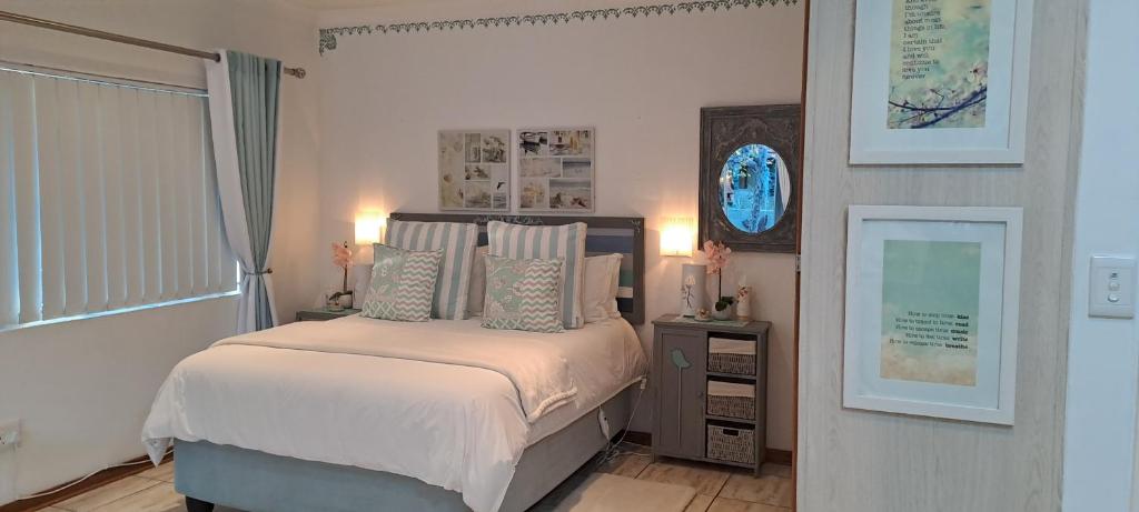 a bedroom with a bed and a clock on the wall at Gabbys Cottage Guesthouse in Bloemfontein