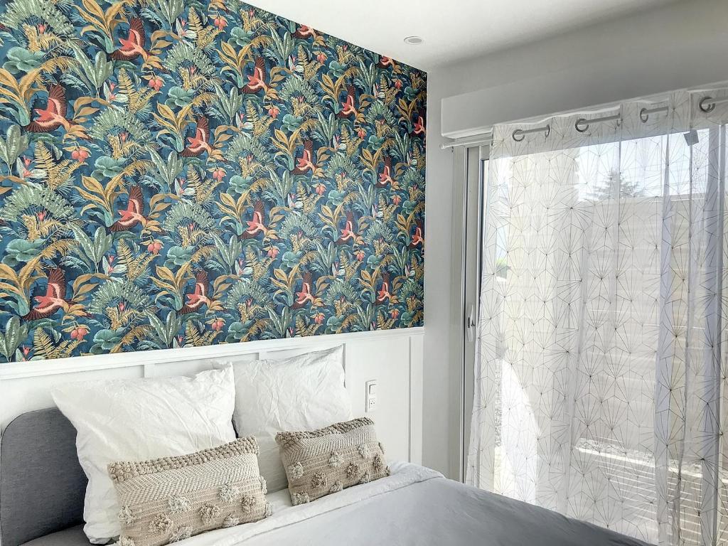 1 dormitorio con un gran mural floral junto a la cama en Résidence Appartements Niort wifi-parking, en Niort