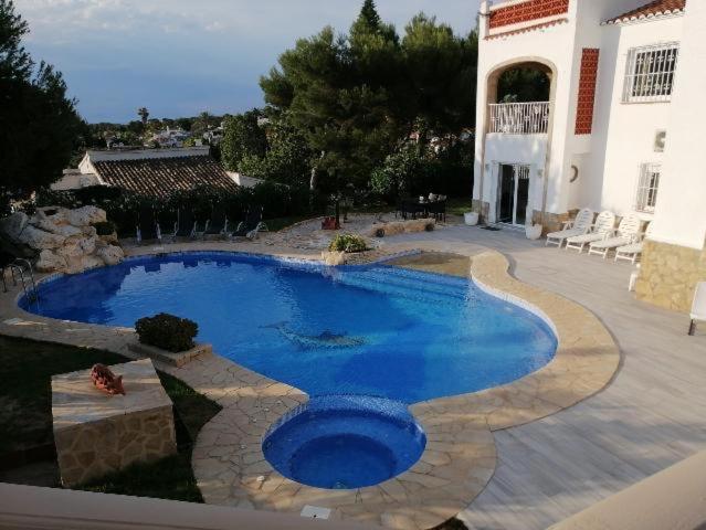 a large swimming pool in the yard of a house at villamarco in Jávea