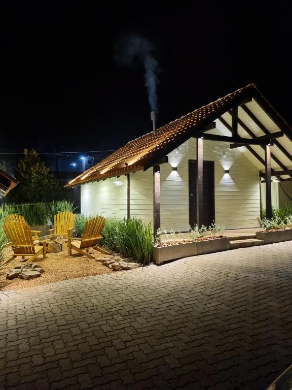 a white building with two chairs and a table at Chalés De Cambará in Cambará