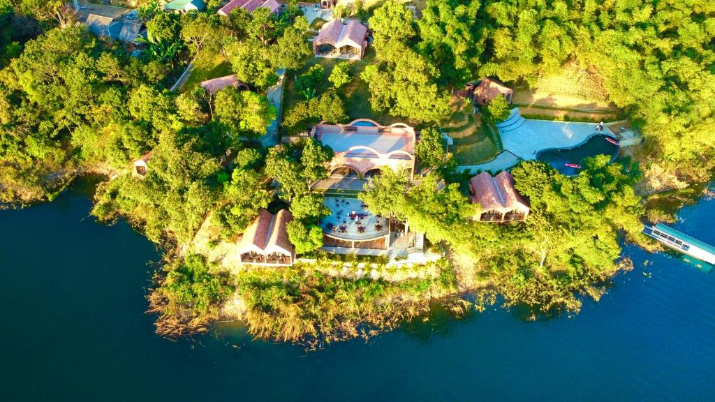 an aerial view of a house on an island in the water at Maida Lodge in Hòa Bình