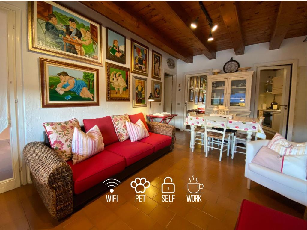 un soggiorno con divano rosso e tavolo di Casa Vista lago - 24h Check in - Free WiFi - Netflix a Monte Isola