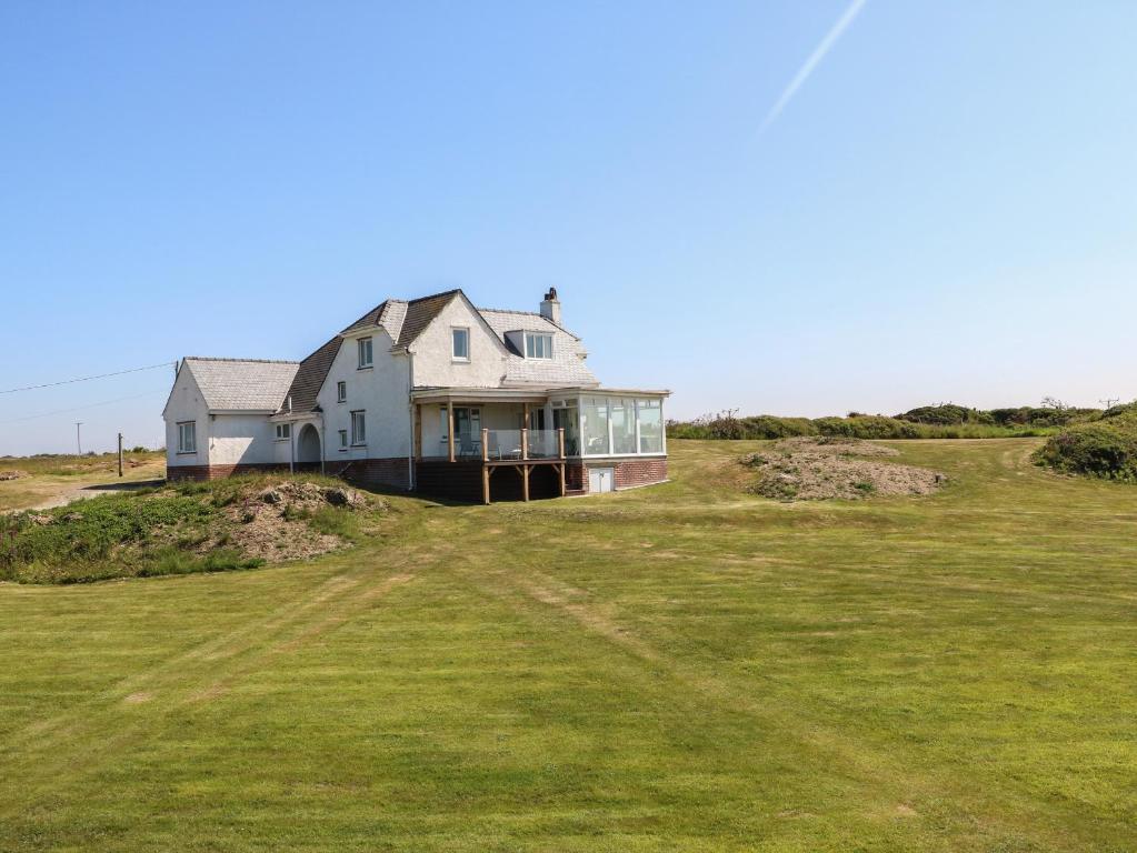 a large house on top of a grassy hill at Wig Carna in Holyhead