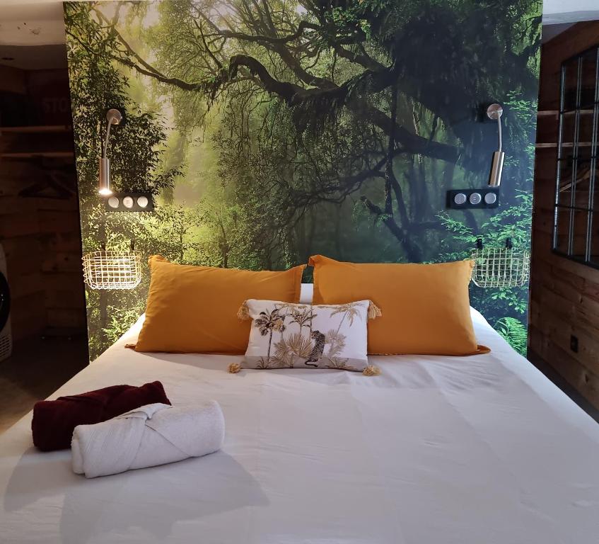 une chambre avec un lit blanc avec des oreillers jaunes dans l'établissement Chez Joy, à Roquebrune-sur Argens