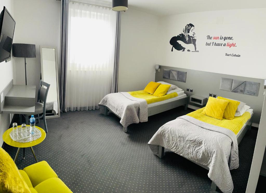 Habitación con 2 camas con almohadas amarillas en Piano, en Nowy Sącz
