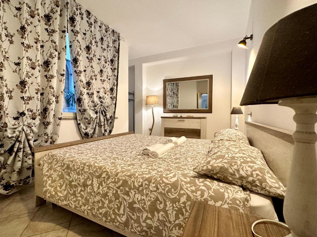 a bedroom with a bed and a mirror and curtains at Arquer43 - Cagliari Old Town in Cagliari