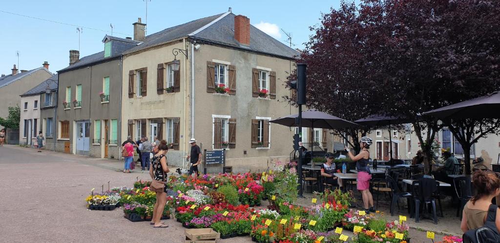 un grupo de personas de pie alrededor de un jardín con flores en Relax au Coeur du Morvan, en Ouroux