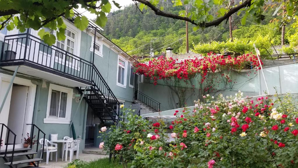 una casa con flores a un lado. en Guest House Green Rose en Borjomi