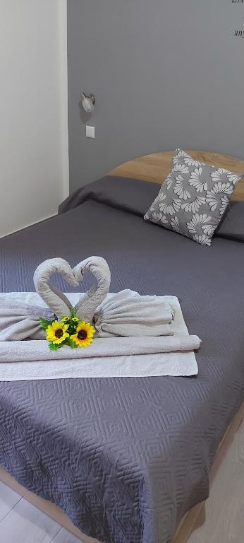 a bed with two towels and flowers on it at Clausis in Parghelia
