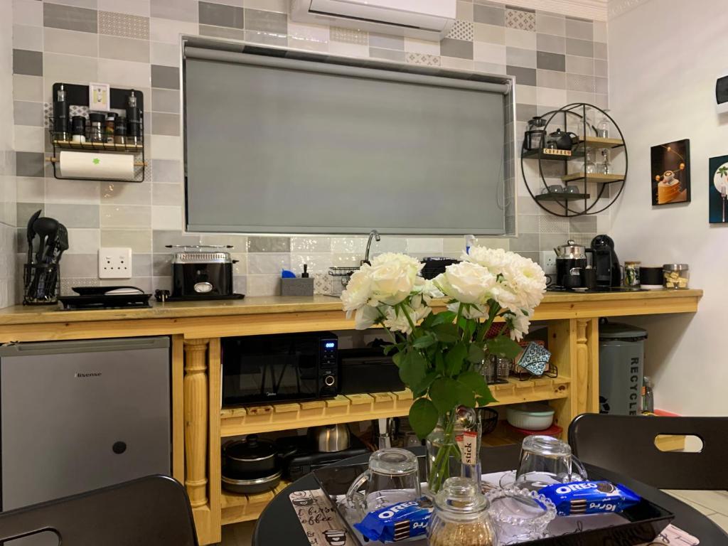 a table with a vase of flowers and a screen at Gabbys Cottage Guesthouse in Bloemfontein