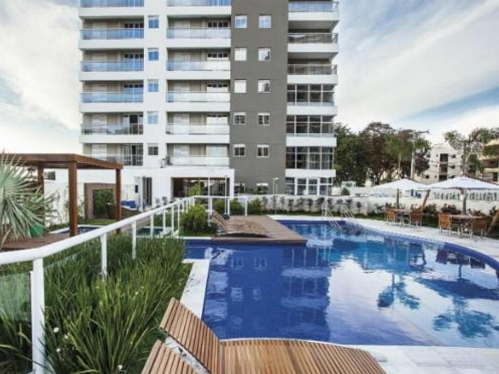 uma piscina em frente a um edifício alto em Condomínio Residencial Spazio Blu - São José do Rio Preto em Sao Jose do Rio Preto