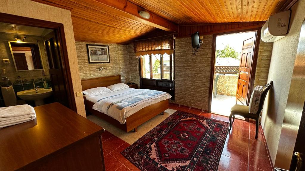 a bedroom with a bed and a bathroom with a sink at Sultan Pension in Antalya