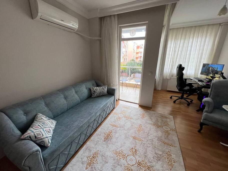 een woonkamer met een blauwe bank en een bureau bij Очень уютная квартира 2+1 in Antalya