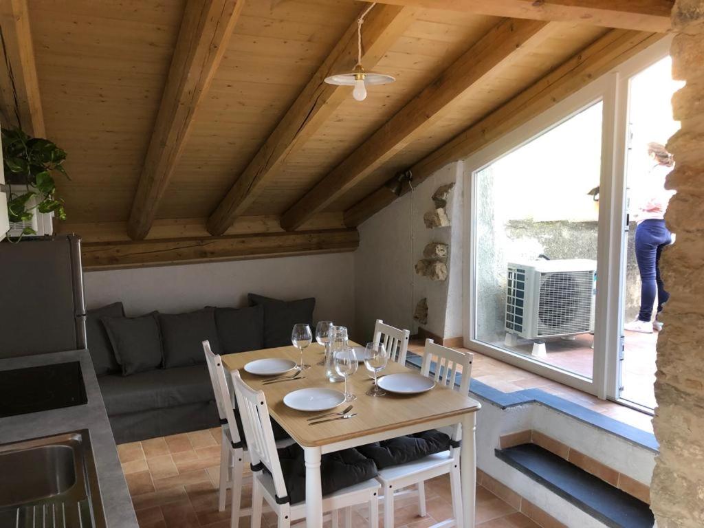 comedor con mesa, sillas y ventana en Cà di Pippo "Tasso" appartamento ristrutturato en Orco Feglino