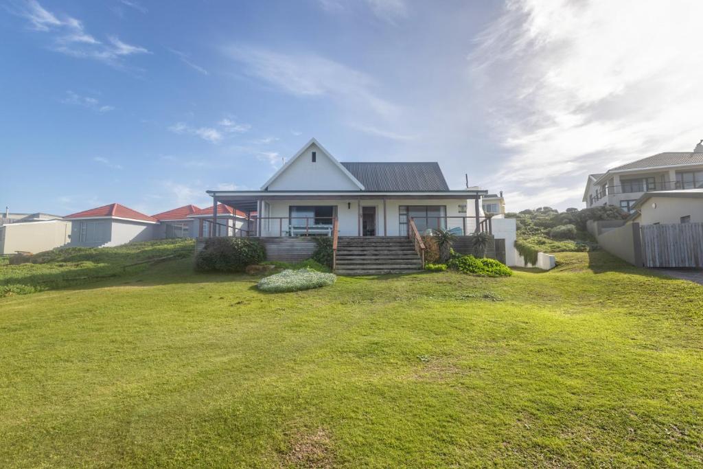 a house on a hill with a yard at The Beauty of The Wildside in Cape St Francis