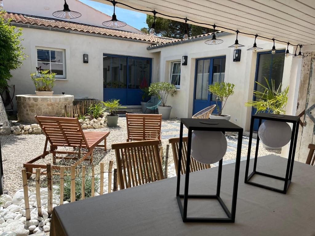 un groupe de chaises et de tables sur une terrasse dans l'établissement Le Clos de Flo, à Saint-Rogatien