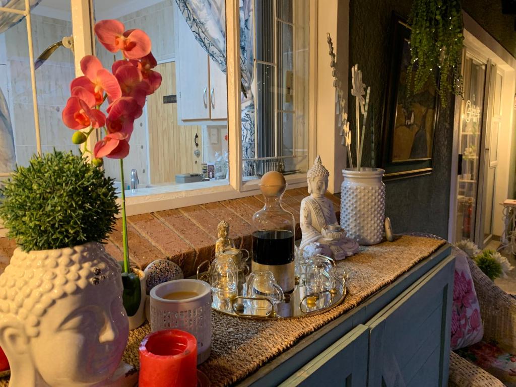 a counter with vases and other items on it at Gabbys Cottage Guesthouse in Bloemfontein