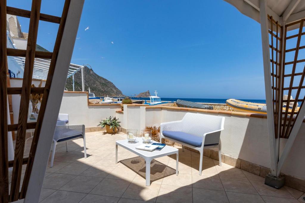 a balcony with a table and chairs and the ocean at Casa Conte Pio in Marettimo