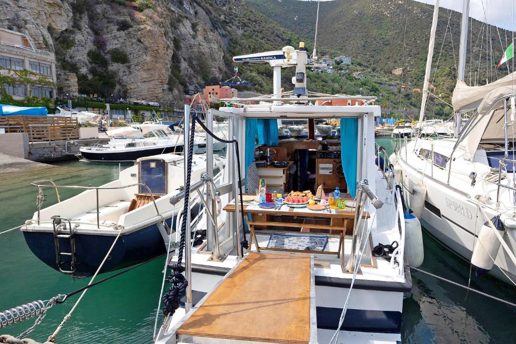 two boats docked in a harbor with a table on it at Aloha Jak's Boat in Alassio