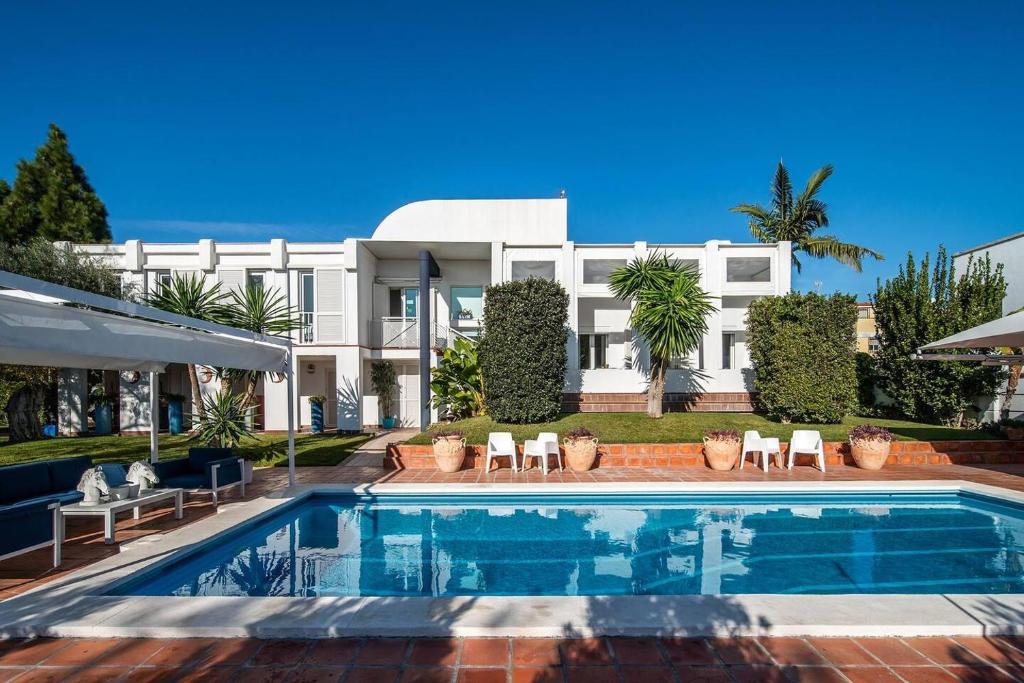 una piscina di fronte a un edificio bianco di Charming 10 person Villa in Sevilla a Tomares