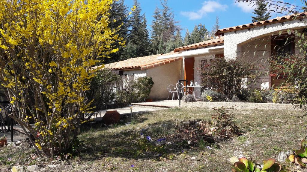 a house with a garden in front of it at VILLA LA LURETTE, appartement et studio in Saint-Étienne-les-Orgues