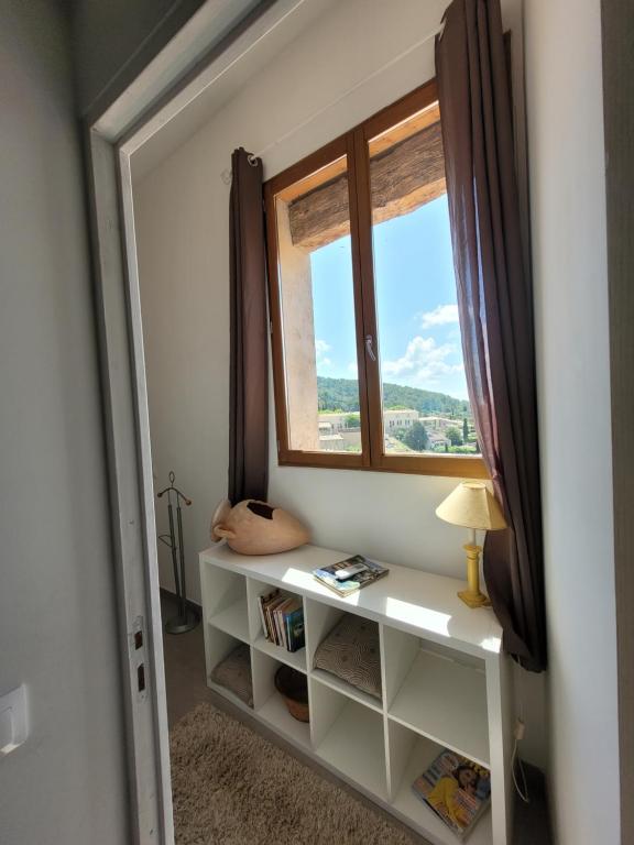 una stanza con finestra e mensola con libri di Charmant Duplex au cœur du village a Cotignac