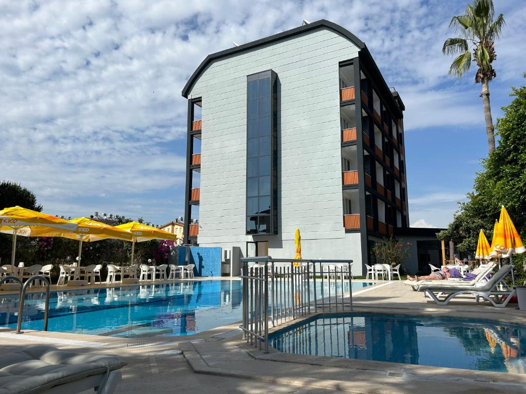 um hotel com piscina em frente a um edifício em Bellissima Hotel em Side