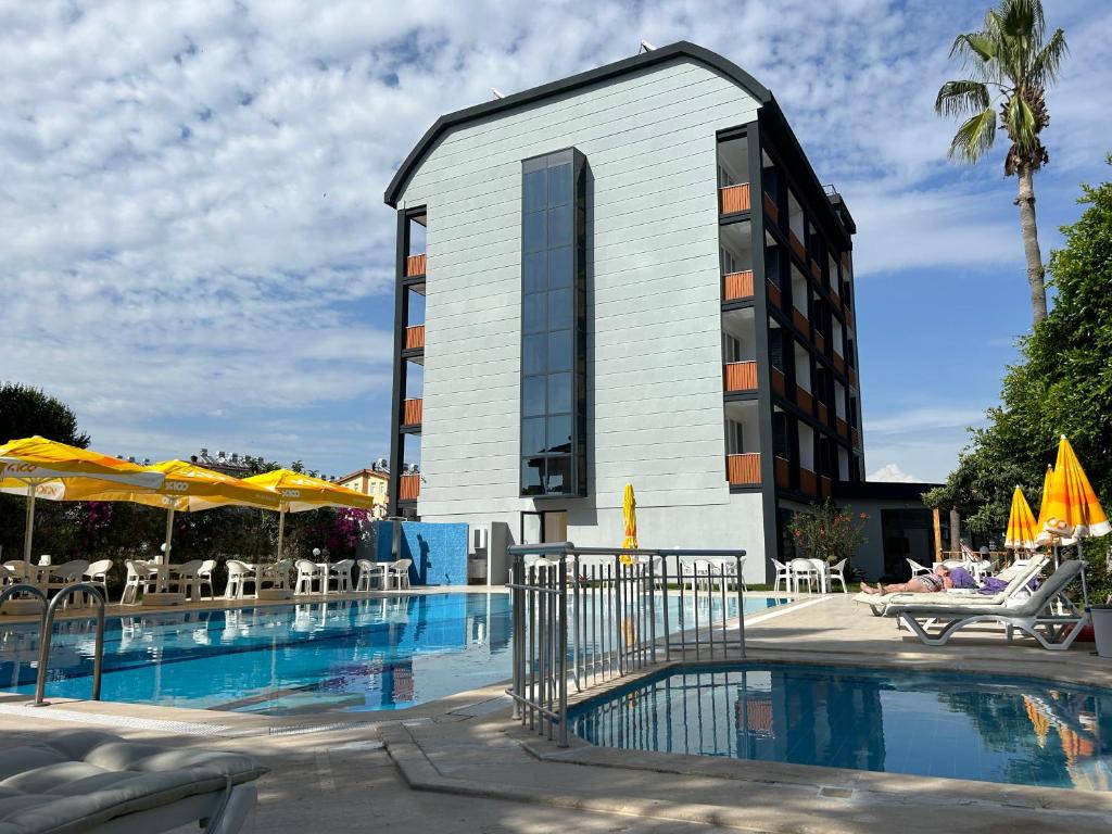 un hotel con piscina frente a un edificio en Bellissima Hotel en Side
