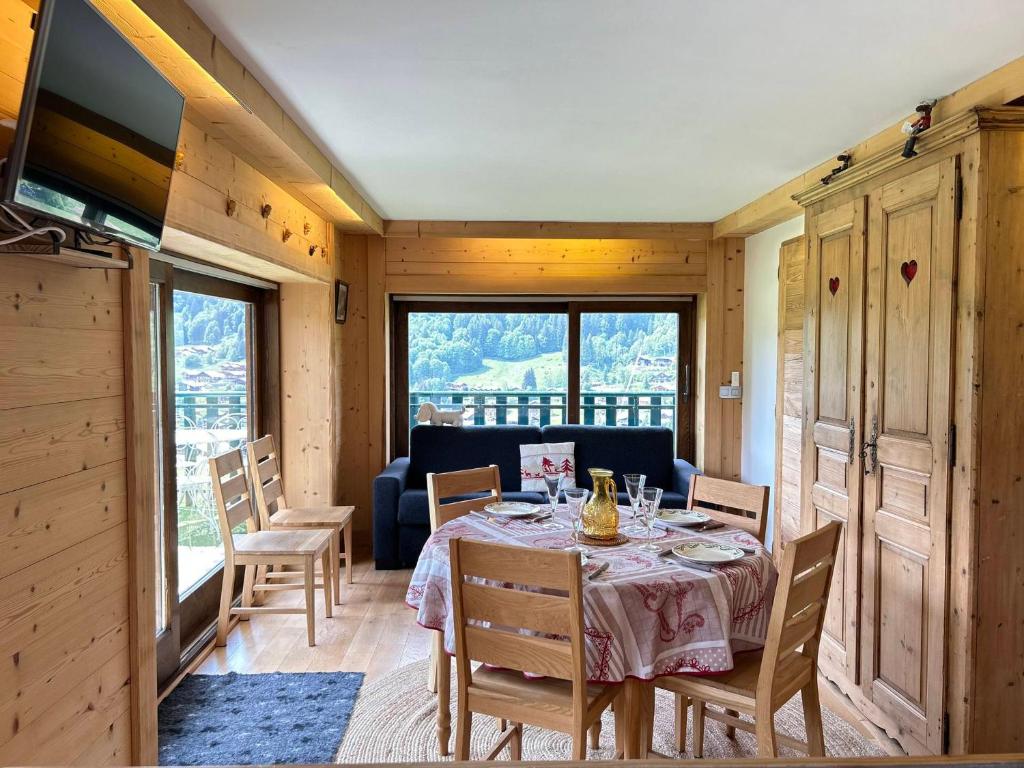 une salle à manger avec une table, des chaises et un canapé dans l'établissement Les Gets - Appartement Le Grizzli - Pistes des Chavannes et Piscine Chauffée - FR-1-623-43, aux Gets
