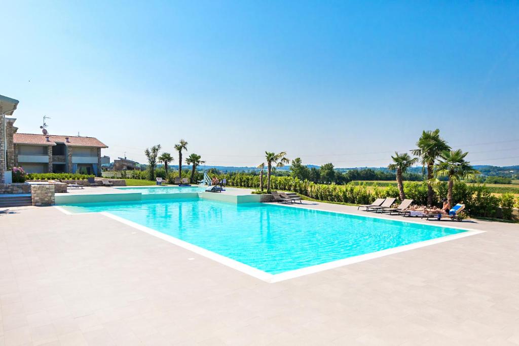 una piscina en una villa con palmeras en Le Mele 7 by Wonderful Italy, en Lonato