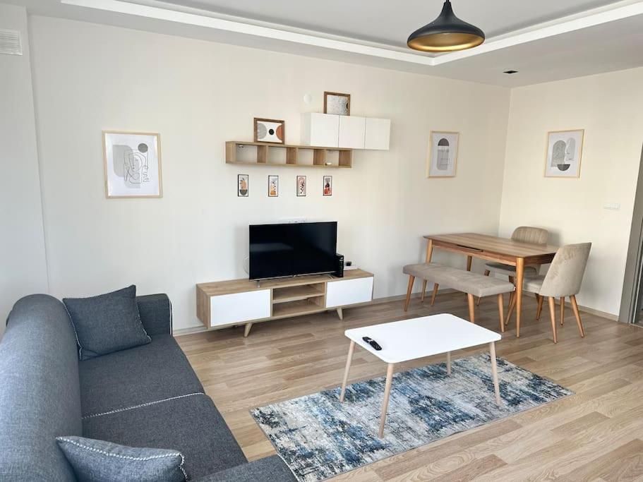 sala de estar con sofá y mesa en Mükkemmel konumda modern daire, en Antalya