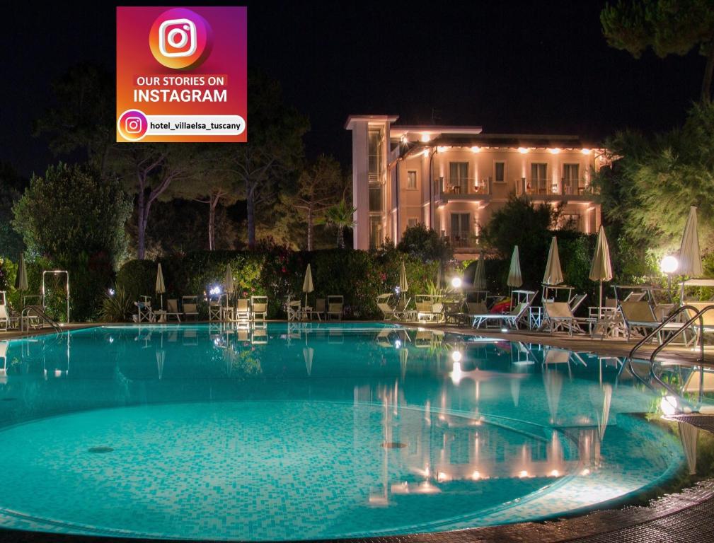 een groot zwembad voor een gebouw 's nachts bij Hotel Villa Elsa in Marina di Massa