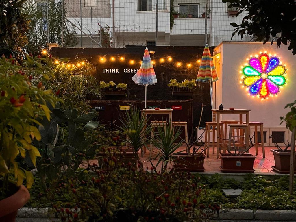 un jardín con una flor iluminada en la pared en Urban Oasis Hostel en Lecce