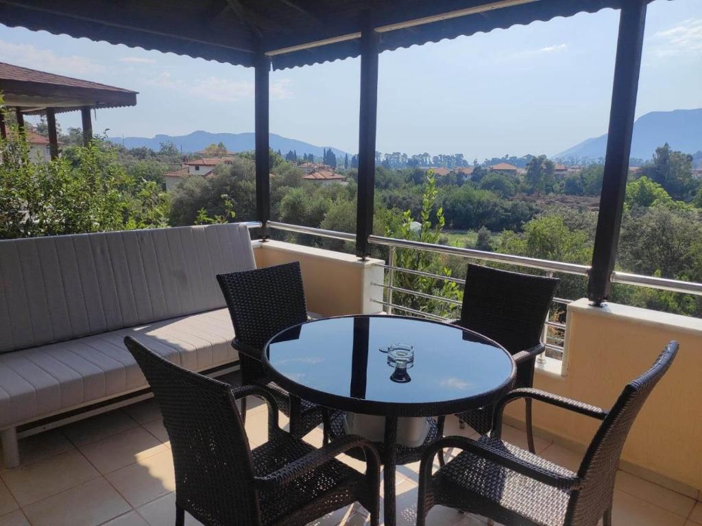 eine Terrasse mit einem Tisch und Stühlen auf dem Balkon in der Unterkunft Ege Homes in Ula