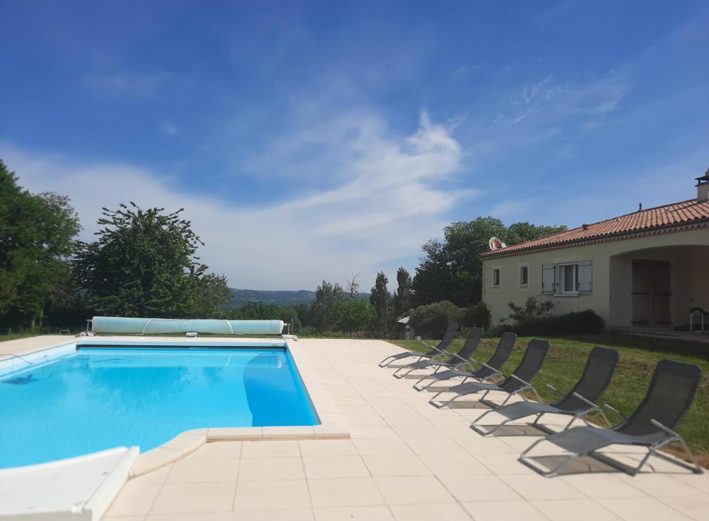 een zwembad met stoelen en een huis bij Chez Papi à Lascaux in Montignac