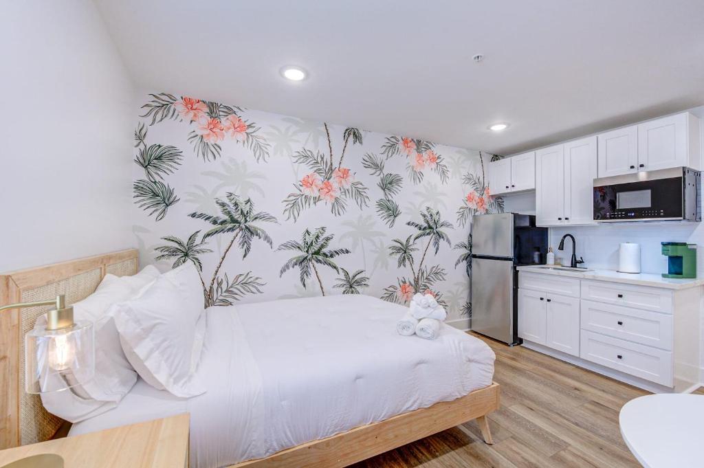- une chambre avec un grand lit et du papier peint tropical dans l'établissement In Living Coral Studio Apartment, à Galveston