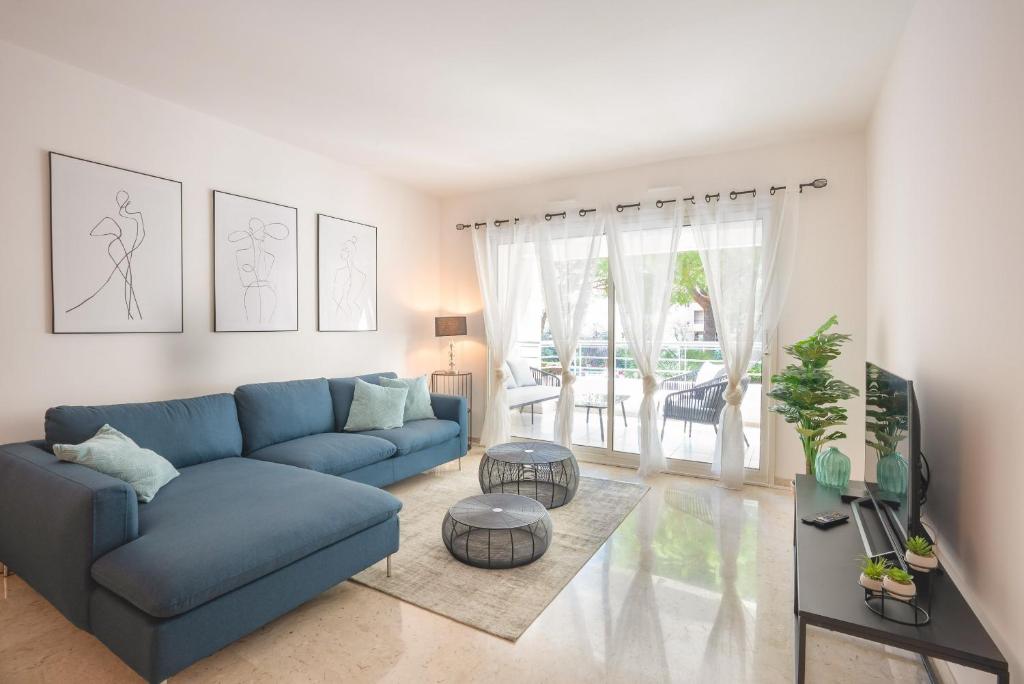 un salon avec un canapé bleu et une télévision dans l'établissement Le Dolce Vita by Winsome Destination, à Cannes