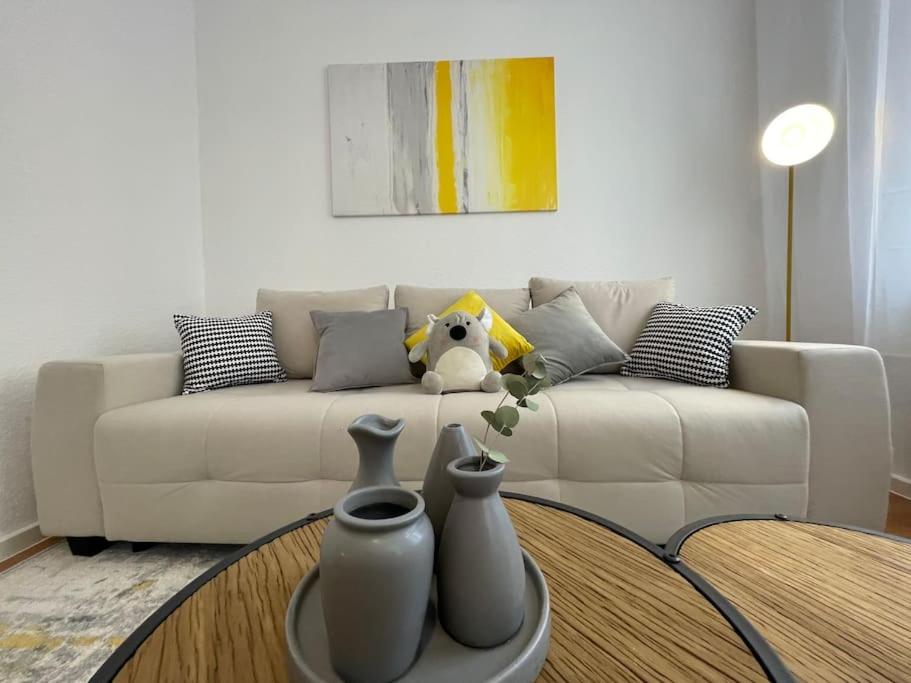ein Wohnzimmer mit einem weißen Sofa und einem Tisch in der Unterkunft LUCKY STAYS LS01 - 2 Zimmer - Luxus - Zentrum - große Küche - Aufzug - Smart-TV in Magdeburg