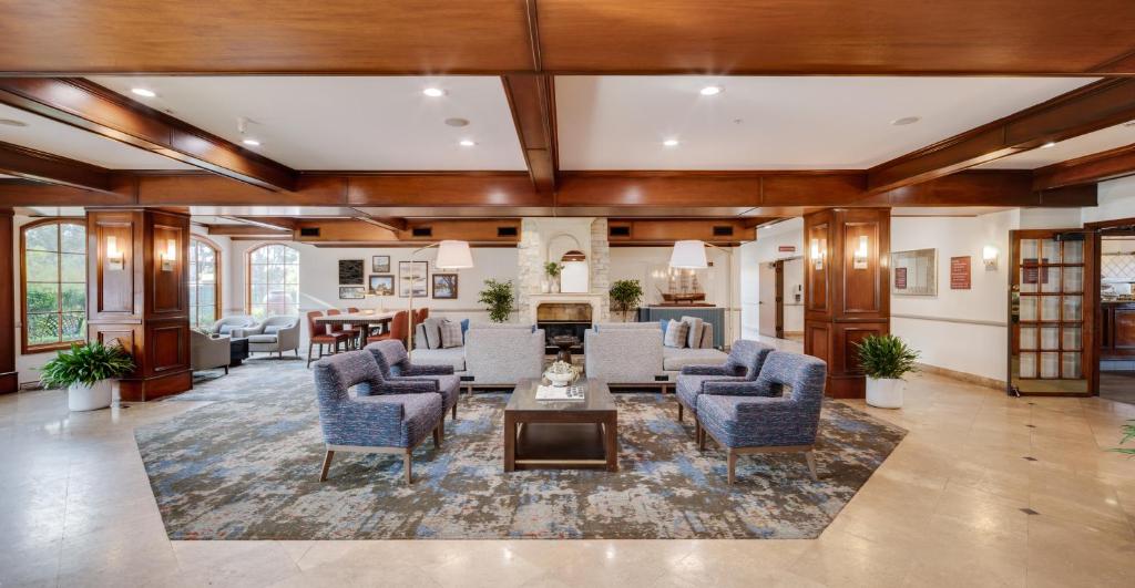 a large living room with blue chairs and a table at Ayres Suites Mission Viejo - Lake Forest in Mission Viejo