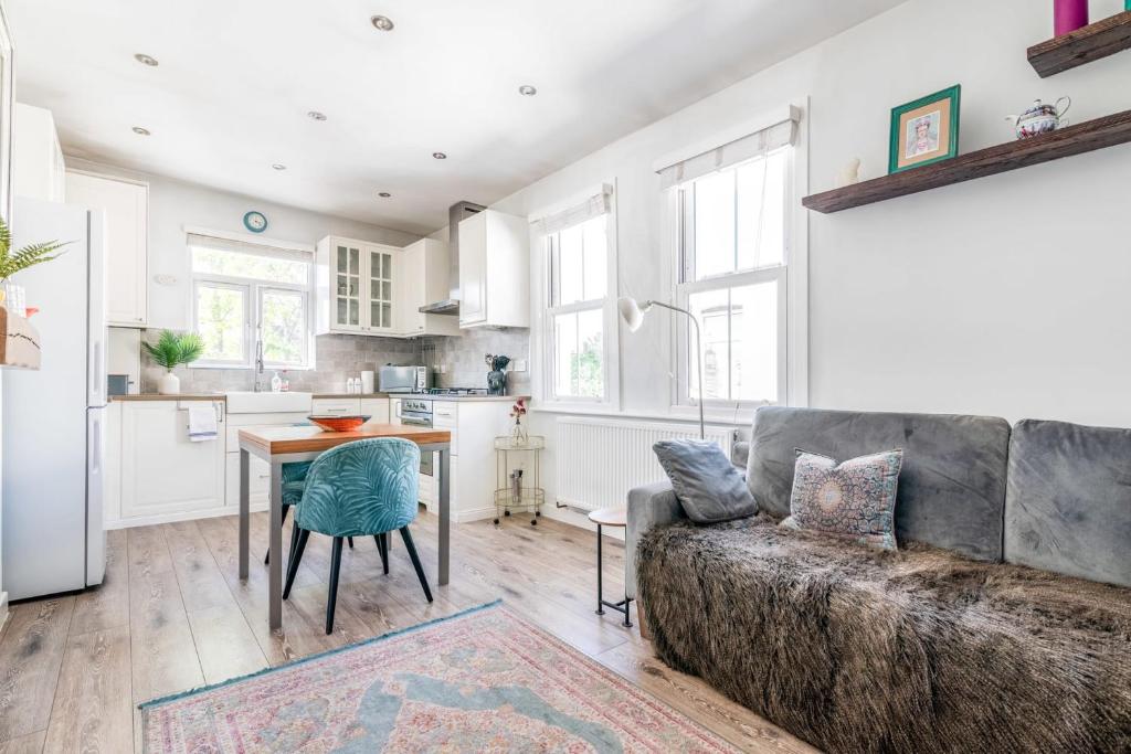 een woonkamer met een bank en een tafel bij Chic and Cheerful Flat in Willesden Green in Londen