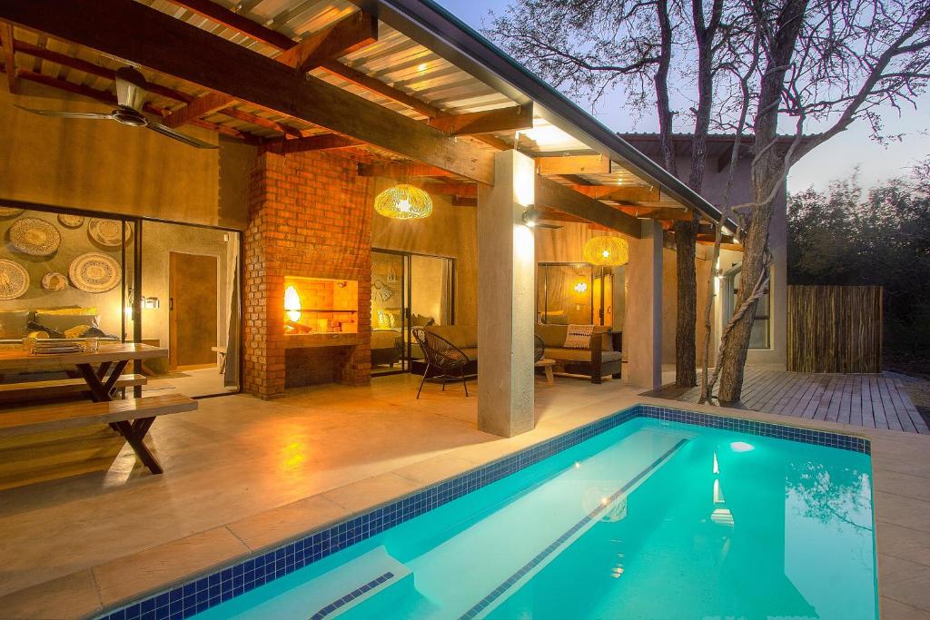 a swimming pool in a house with a patio at Ibhubesi house in Marloth Park
