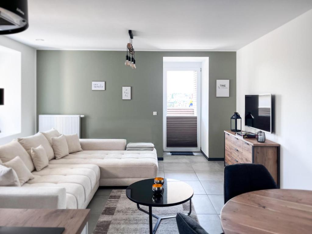 a living room with a white couch and a table at Hof Gemehret in Eupen