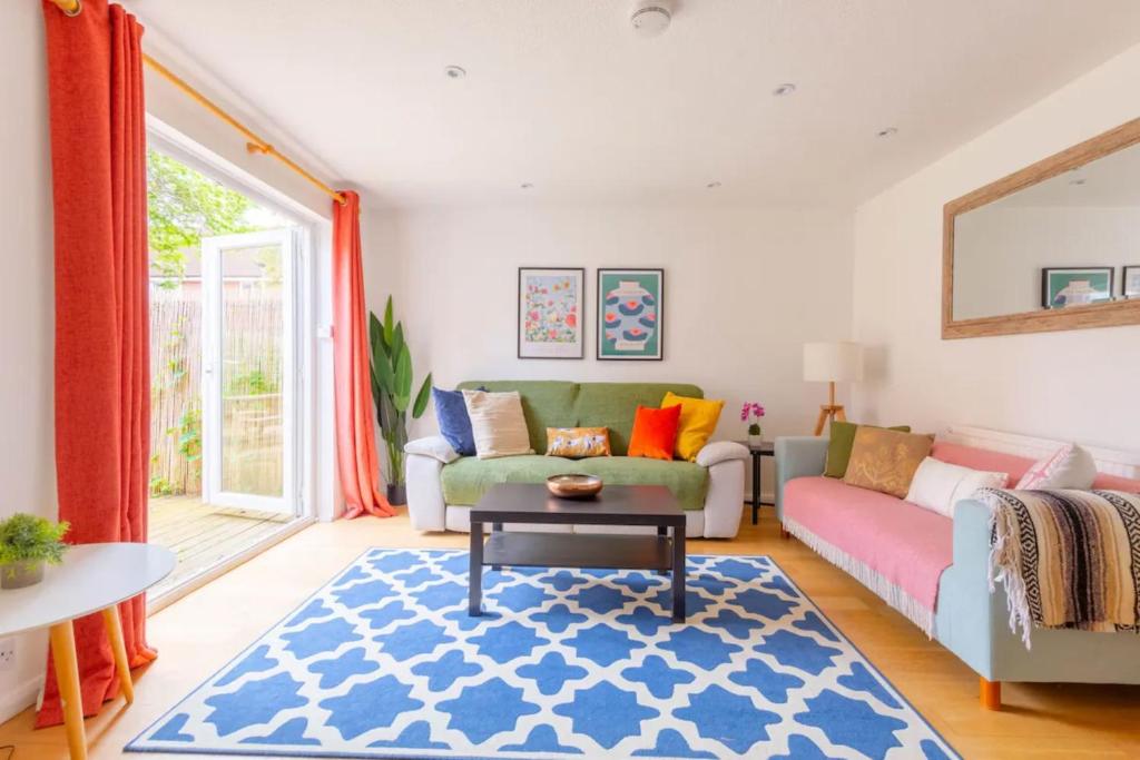 un soggiorno con divano e tavolo di Bright 3 Bedroom House with Terrace 16 mins to Big Ben a Londra